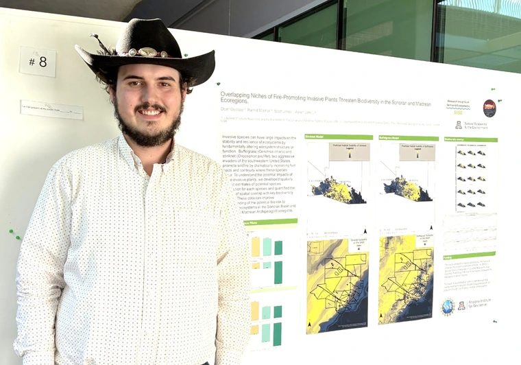 Doan Goolsby next to his poster